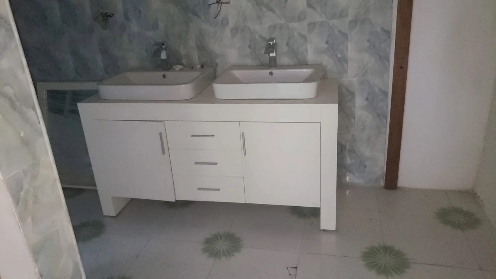 Bathroom improvement with a double vanity and stone-look wall finish.