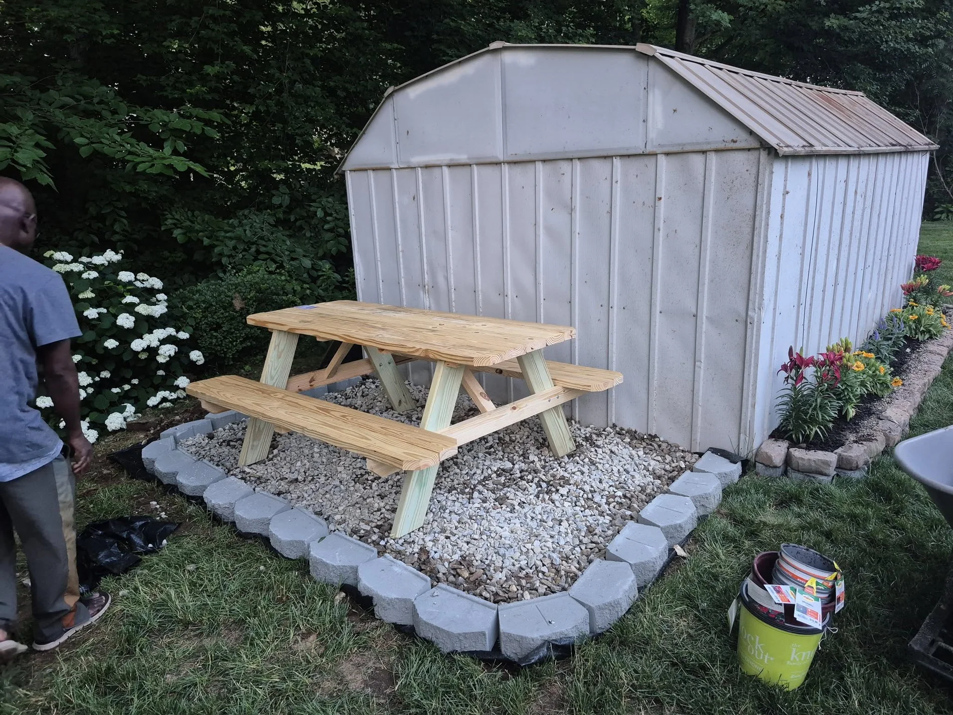 Landscape and patio-area improvement around an outdoor structure.